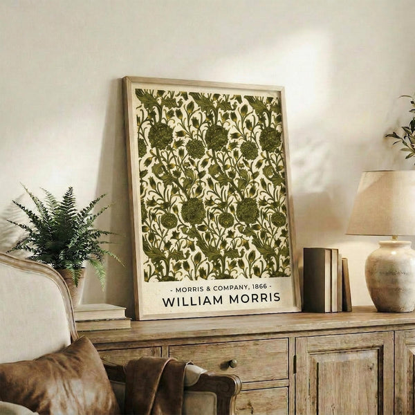 May include: Framed botanical poster with green floral pattern featuring ornate flowers and leaves on cream background, displayed on rustic wooden sideboard alongside fern plant, books, and ceramic vases in neutral-toned living room setting