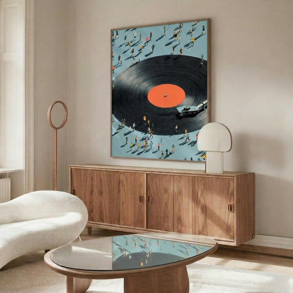 May include: Modern living room mockup showing framed artwork on wall above wooden credenza. Art depicts large black vinyl record with orange label surrounded by tiny people figures on light blue background. White curved chair and glass coffee table with matching design visible. Warm wood tones and neutral decor create mid-century modern aesthetic.