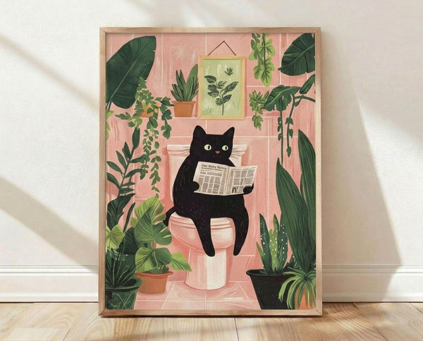 May include: Framed artwork displaying a whimsical black cat with yellow eyes sitting on a toilet reading a newspaper, surrounded by lush green houseplants including snake plants, trailing pothos, and leafy tropicals in terracotta pots. The illustration features soft pink bathroom tiles, botanical wall art, and is shown in a light wood frame leaning against a white wall on wooden flooring with natural shadows.