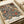 Ornate floral pattern poster with intricate botanical design featuring roses, chrysanthemums, and decorative leaves in rich navy blue, coral red, and cream colors. The detailed Victorian-style artwork is printed on cream paper and lies flat on a white surface next to rolled white paper, showing the vintage Morris & Company 1866 attribution at the bottom.