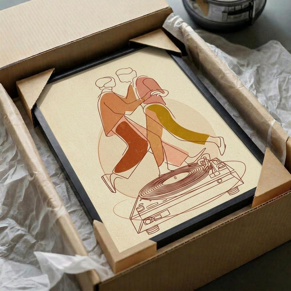 May include: Framed poster artwork showing abstract line drawing of dancing couple in warm coral, orange and yellow tones above detailed turntable illustration. Black frame sits in cardboard shipping box with tissue paper and cardboard tubes on white surface.