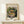 May include: Framed vintage art poster featuring a colorful still life painting of goldfish in a glass bowl surrounded by lush green plants and purple flowers. The cream-colored poster displays "MATISSE" and "The Pushkin State museum of Fine Arts" text above the artwork. The wooden frame sits on a light wood shelf against a white wall, with a small wrapped gift box beside it.