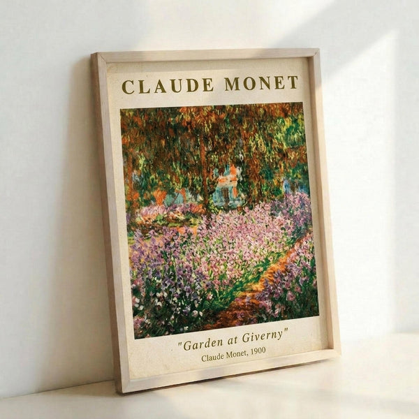 May include: Framed art print of Claude Monet's impressionist garden painting featuring vibrant pink flowers in foreground with lush green foliage and trees in background. Light wood frame displays poster with cream background and text identifying artwork as "Garden at Giverny" from 1900. Print leans against white wall casting soft shadows.