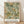 May include: Framed botanical art print with William Morris design featuring sage green background with intricate floral pattern in coral, cream and gold tones. Delicate branches, leaves and small clustered flowers create an ornate vintage wallpaper style. Light wood frame sits on wooden floor against white textured wall with soft natural lighting casting shadows.