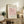 May include: Framed art print featuring minimalist line drawing of pink flamingo on rose background, displayed on rustic wooden console with books, ceramic vases, and fern plant. Cream matting in light wood frame against neutral wall in modern living room setting.