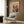 a modern living room with a white armchair, a floor lamp, and a framed poster of a colorful abstract painting on the wall.