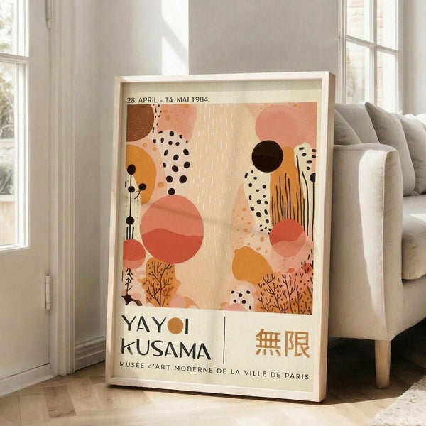 A framed poster of Yayoi Kusama's exhibition titled "Musee d'Art Moderne de la Ville de Paris" is displayed on a wooden floor next to a couch.