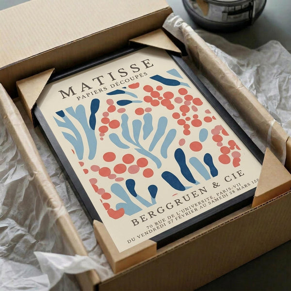 a framed poster of the Matisse painting "Papiers Découpes" (Paper Decoupes) in a cardboard box.