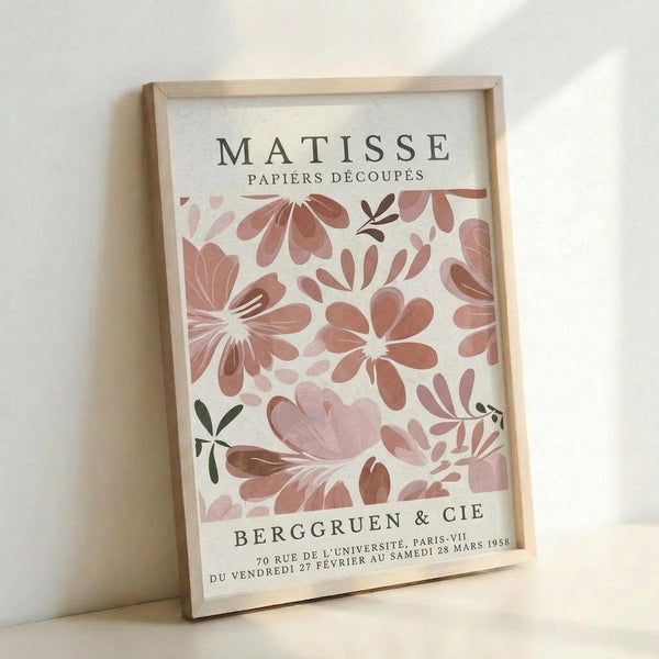 The image is a framed poster featuring a floral design with pink and brown flowers. The poster is titled "MATISSE Papiers Decoupes" and includes the text "BERGGRUEN & CIE" and "70 RUE DE L'UNIVERSITE, PARIS, VI" along with the date "28 MARS 1958".
