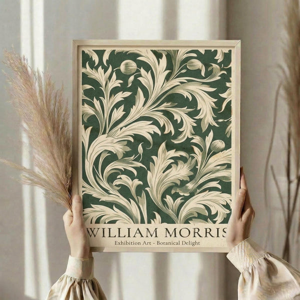 A person's hands holding a framed poster with a floral design in shades of green and white.