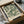 A framed poster of William Morris' botanical design is displayed in a cardboard box, with a white tissue paper lining the box.