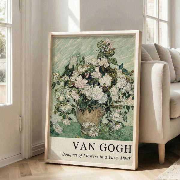 May include: Framed Van Gogh reproduction print showing white roses in a vase against mint green background, leaning against white wall next to beige upholstered chair. Natural light streams through windows onto hardwood floor. The artwork features thick brushstrokes and swirling textures typical of Van Gogh's style, with abundant white blooms and dark green foliage filling an earthenware vase.