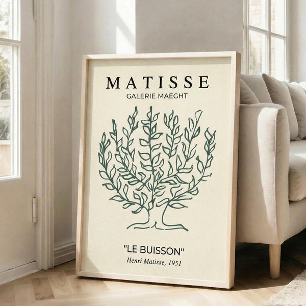 May include: Framed botanical art print featuring a stylized green tree illustration on cream background, displayed in light wood frame against white wall in bright living room with beige sofa and large windows. Modern minimalist home decor setting with natural lighting casting soft shadows on hardwood floors.