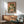 May include: Japanese-style vintage poster artwork featuring a green frog with chopsticks eating noodles from a ramen bowl, displayed in wooden frame above mid-century modern credenza with white ceramic lamp, next to teal upholstered armchair in bright sunlit room with white walls and hardwood floors.