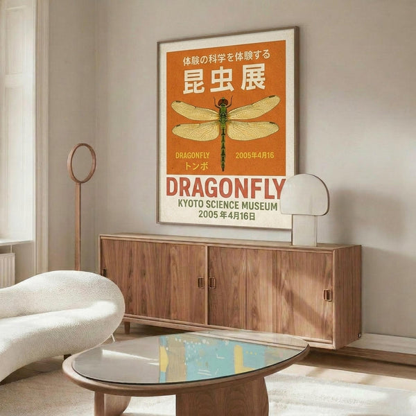 May include: Orange and cream vintage-style dragonfly poster in thin frame hanging above mid-century walnut credenza in modern living room. Poster features detailed green dragonfly illustration with Japanese text. Room has cream upholstered chair, brass floor lamp, oval glass coffee table, and neutral decor creating minimalist aesthetic.