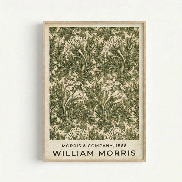 Framed vintage botanical wallpaper pattern print featuring intricate green acanthus leaves and ornate floral motifs on cream background. The detailed Arts and Crafts style design shows repeating symmetrical foliage with flowing, curved stems. Text at bottom reads "Morris & Company, 1866" and "William Morris" in dark lettering. Light wood frame hangs on white wall.