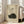 May include: A framed vintage-style poster featuring a sleeping black cat curled in a ball with Japanese calligraphy text above it on beige textured paper, displayed in a light wood frame leaning against white walls in a bright living room with beige furniture and large windows