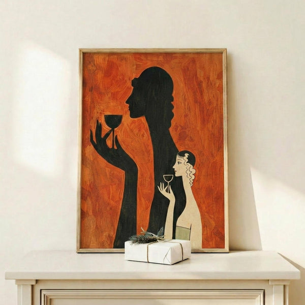 May include: Framed art print with orange textured background featuring black silhouette of elegant woman holding wine glass and smaller illustrated woman also with wine glass, displayed on light wood console table next to wrapped white gift box with natural greenery accent against white wall
