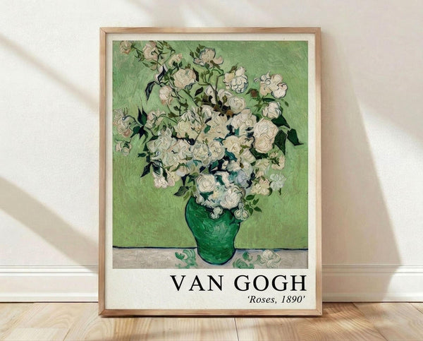 May include: Framed poster print of Van Gogh's white roses painting in green vase against mint green background, displayed in light wood frame on wooden floor against white wall with natural sunlight shadows. The artwork shows thick impasto brushstrokes and Post-Impressionist style with "VAN GOGH Roses, 1890" text below the image.