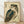 May include: Framed vintage Japanese woodblock print of an owl with detailed brown and teal feathers, large orange eyes, and Japanese calligraphy on cream background. Light wood frame leaning against white wall on wooden floor with soft natural lighting casting shadows.