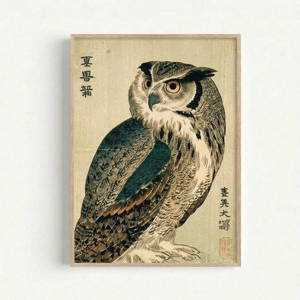 Japanese woodblock print of an owl with intricate feather details in teal, brown, and cream colors. The bird has large golden eyes and detailed plumage against a beige background. Black Japanese characters appear in the upper left and lower right corners with a red artist's seal. The artwork is displayed in a light wooden frame against a white wall.