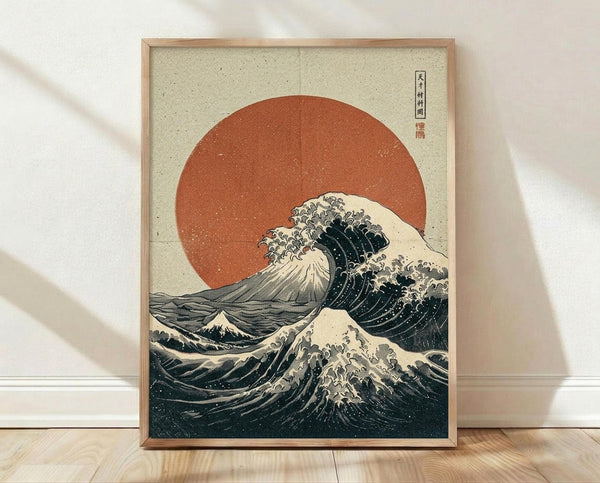 May include: Framed poster print leaning against white wall on light wood floor. Features Japanese woodblock style artwork with large dark blue ocean wave with white foam, orange-red sun in background, and Mount Fuji silhouette. Traditional beige textured paper appearance with Japanese characters in upper right corner. Natural wood frame, soft lighting creates diagonal shadows across scene.