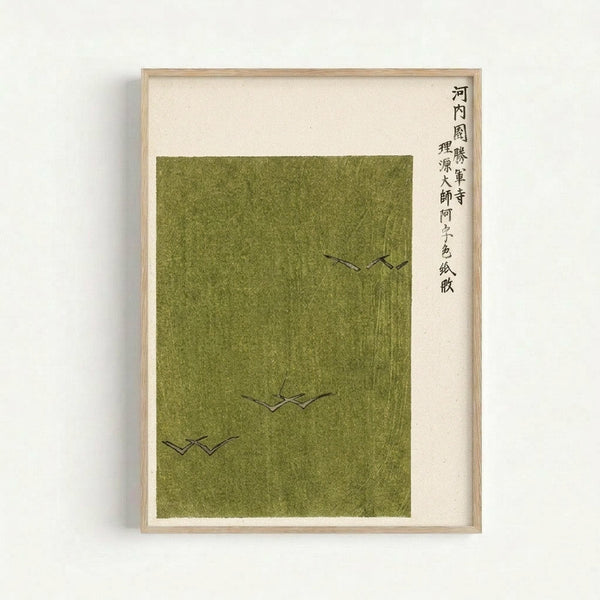 Framed minimalist Japanese artwork featuring three simple black line drawings of birds in flight against a muted olive green textured background. The piece includes vertical Japanese calligraphy text on the right side against cream-colored paper. The artwork is displayed in a light wood frame against a white wall, showing subtle texture and weathered appearance of the green background material.