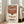 May include: Large framed poster of Campbell's condensed tomato soup can with red and white label, displayed in bright living room with beige sofa, white walls, and tall windows. The vintage-style artwork shows classic soup can design with script lettering and circular logo seal.