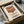 May include: Vintage-style Campbell's condensed tomato soup can poster print in warm red and cream colors, displayed in black frame inside cardboard shipping box with tissue paper and wooden dowels for protection. The retro artwork shows classic soup can design with script lettering and circular logo medallion.