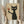 May include: Person in beige ruffled sleeve top holding framed artwork showing black cat with yellow eyes holding wine glass with red wine, standing by window with dried pampas grass, cream colored walls and natural lighting