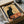 May include: Vintage French poster reproduction featuring iconic black cat silhouette with yellow eyes and ornate decorative halo, displayed in black frame within cardboard shipping box surrounded by white tissue paper and wooden dowels for protection. Art nouveau style artwork in warm yellow and orange tones with elegant French typography.