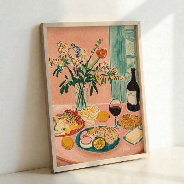 May include: Framed art print leaning against white wall showing colorful still life scene with wildflower bouquet in glass vase, wine bottle and glass, plates of food including sliced eggs and bread, all arranged on pink tablecloth. Features coral pink background, turquoise curtains, and vibrant colors in an illustrative style reminiscent of mid-century modern art.