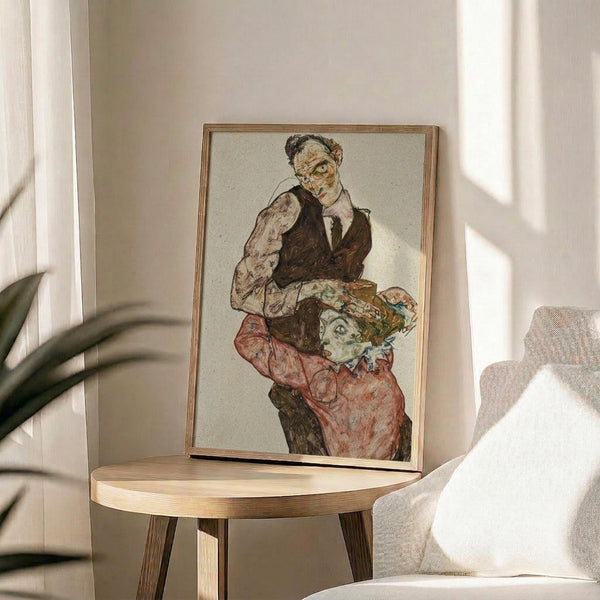 May include: Framed expressionist artwork showing a man in dark vest holding a woman in red dress, displayed on round wooden side table next to beige upholstered chair. Natural sunlight creates shadows across white walls. Green plant leaves visible in corner. Artwork features muted earth tones and sketchy, angular style characteristic of early 20th century Austrian expressionism.
