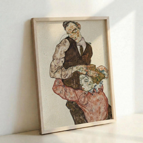May include: Framed art print leaning against white wall showing expressionist drawing of two figures - older man in dark vest and white shirt above, younger person in coral-pink garment below. Artwork features bold outlines, muted earth tones, and characteristic early 20th century Austrian expressionist style. Light wooden frame contains cream-colored print on textured paper background.