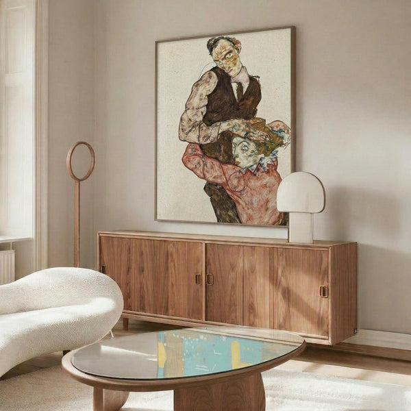 May include: Framed reproduction of early 20th century expressionist artwork showing two figures in dark formal wear against cream background, displayed above walnut wood credenza in modern living room with white curved chair, brass floor lamp, oval glass coffee table, and neutral walls with natural lighting
