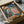 May include: Framed reproduction of early 20th century painting showing two figures in colorful clothing - one in checkered pattern, another in pink top - carefully packed in cardboard shipping box with protective tissue paper and wooden frame supports visible around edges.