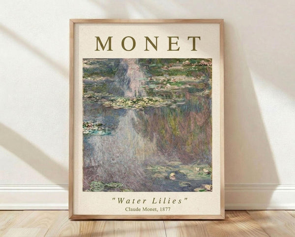 May include: Framed poster print of Monet's Water Lilies painting displayed on light wooden floor against white textured wall with soft natural lighting. The artwork shows impressionistic water lilies floating on a pond with reflective water in muted greens, blues, and purples. Cream-colored background with "MONET" in olive green text above the image and "Water Lilies" and "Claude Monet, 1877" below in smaller text. Simple light wood frame.