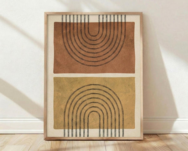 May include: Framed abstract art print featuring two overlapping arch designs with concentric line patterns. Top arch in terracotta orange, bottom arch in mustard yellow, both on cream background. Light wood frame displayed on wooden floor against white wall with natural lighting and soft shadows.