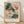 May include: Framed botanical art print with abstract painted flowers in soft pink, coral, and sage green brushstrokes displayed in light wood frame against white textured wall. Print shows impressionistic floral design with flowing paint strokes and French text below artwork. Frame sits on light wooden floor with natural window shadows cast across scene.