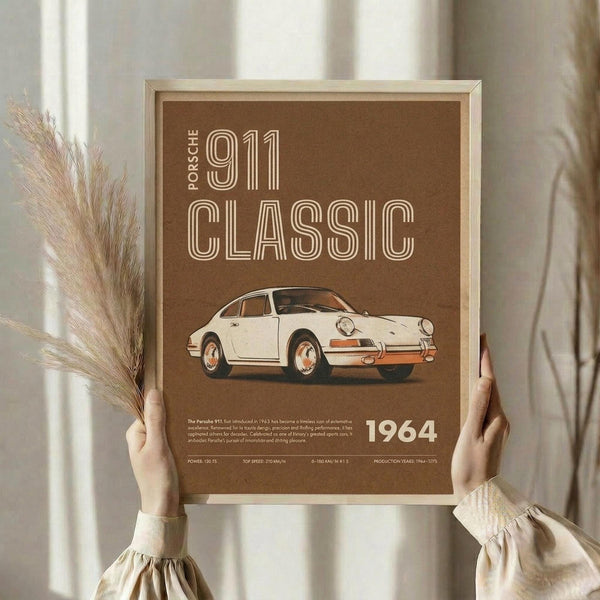 May include: Framed vintage-style poster with brown background featuring cream-colored Porsche 911 classic car illustration and "1964" text, held by person in beige clothing with dried pampas grass, photographed against neutral curtained window background in natural lighting