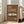 May include: Framed vintage-style poster featuring white classic sports car on brown background with cream text reading "911 CLASSIC" and "1964", displayed on wooden floor against beige couch in bright living room with white walls and windows