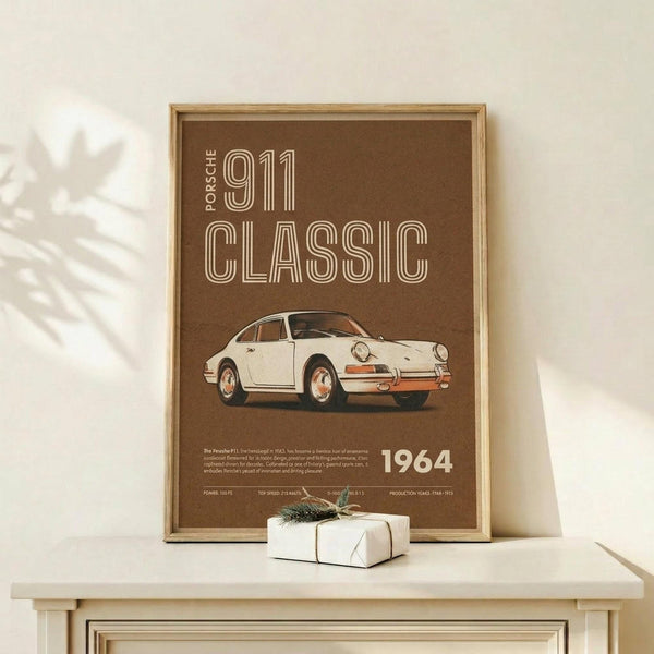 May include: Vintage-style brown poster featuring cream-colored Porsche 911 sports car with "PORSCHE 911 CLASSIC 1964" text in retro typography, displayed in natural wood frame on light wooden surface beside small wrapped white gift with pine sprig, photographed against cream wall with soft plant shadows
