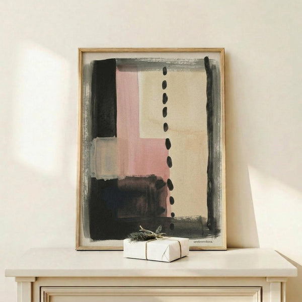 May include: Abstract artwork in natural wood frame displayed on light wooden surface with small wrapped gift. The painting features geometric blocks in soft pink, cream, and charcoal gray with vertical row of black dots down center, set against minimalist white wall background.