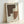 May include: Framed abstract geometric artwork leaning against white wall, featuring overlapping shapes in brown, beige, and cream tones with black polka dot patterns throughout. Natural wood frame with light finish displays the modern composition on textured paper background.