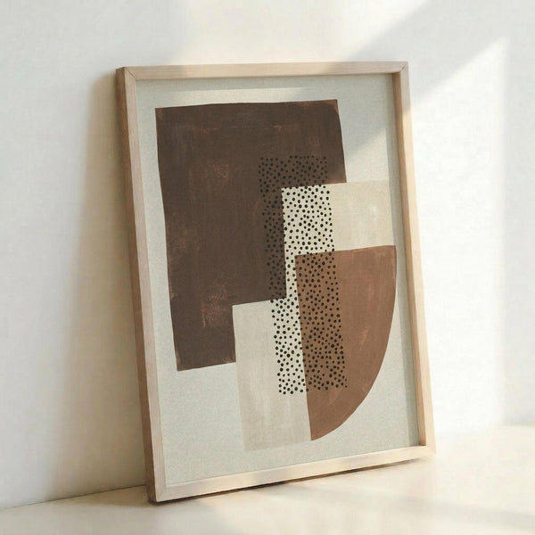 May include: Framed abstract geometric artwork leaning against white wall, featuring overlapping shapes in brown, beige, and cream tones with black polka dot patterns throughout. Natural wood frame with light finish displays the modern composition on textured paper background.