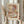May include: Person holding framed abstract art print featuring overlapping geometric circles in warm earth tones of terracotta, beige, cream, and soft blue accents, displayed with dried wheat stems against neutral curtained background in natural lighting