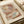 Abstract geometric art print with overlapping circles and curved shapes in warm earth tones of terracotta, sage green, cream, and muted browns. The composition features translucent layered forms creating a harmonious, mid-century modern aesthetic. Print sits on neutral papers with rolled paper tube visible, showing fine art paper texture and clean white border framing the artwork.