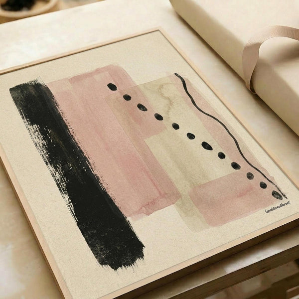 May include: Abstract art print in light wood frame displayed on cream sofa arm. Artwork features soft pink and beige rectangular shapes with black brushstroke on left side, scattered black dots, and curved black line on right. Minimalist contemporary style with muted neutral tones and organic gestural elements on textured paper background.