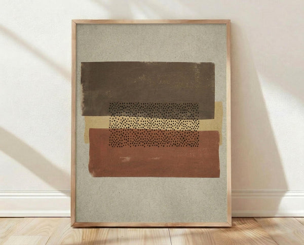 May include: Framed abstract geometric artwork with layered horizontal bands in dark brown, cream, and terracotta colors featuring dotted patterns, displayed in light wood frame against white textured wall on wooden floor with natural lighting creating soft shadows