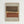 Framed abstract artwork with horizontal bands in brown, cream, and rust orange colors featuring a central dotted pattern. The piece has a textured, earthy appearance on beige paper within a light wood frame, displayed against a white wall.